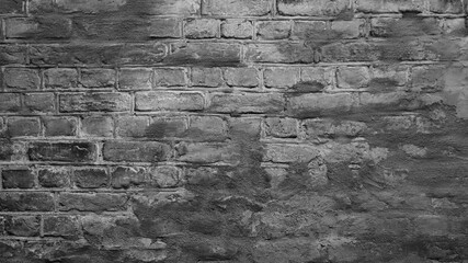 In the photo a close-up of a grey brick and grey plaster wall