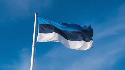 The Estonian flag waving proudly under a clear blue sky