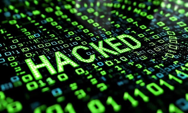 Hacked word in glowing green on a digital binary code background.
