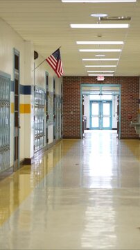 Vertical video empty hallway in high, middle, or elementary school with all the lights on.