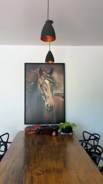 interior de cozinha com mesa rustica e quadro de cavalo decorativo na parede 