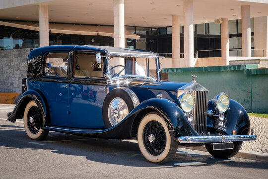 Luxury blue 1937 Rolls-Royce Phantom III in urban setting on sunny day