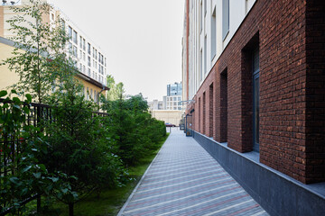 A modern urban pathway enriched with vibrant greenery and beautiful brick architecture