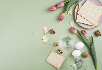 matzah bread, tulips, and candles on a light green background, celebrating passover and springtime