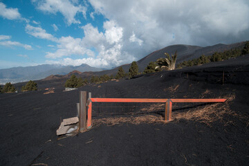 A desolate landscape due to the last volcanic eruption in La Palma with a farm and a house buried...