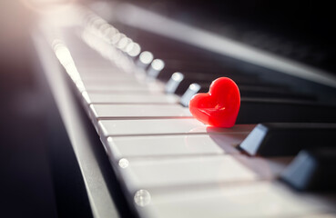 Red heart on piano keys concept for love of music or romance and valentines day