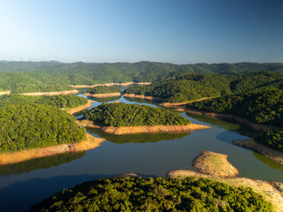 aerial view of the Atlantic forest in Sao Paulo state in Brazil during sunrise showing the nature and a lake © Alexandre