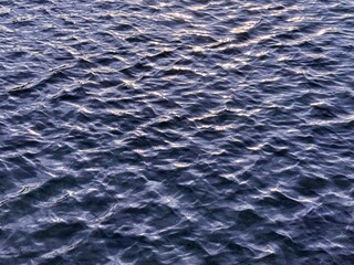 Dark blue ripples river water surface background.