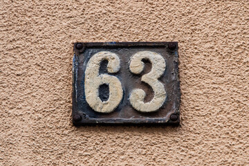 Old retro weathered cast iron plate with number 63