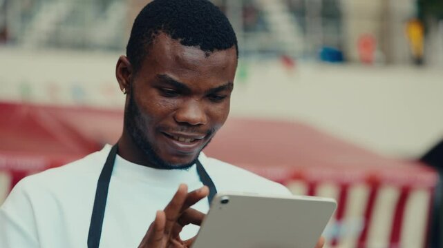 Portrait of African American male manager working on smart tablet in cafe