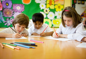 Elementary School: Artists. A small group of young primary school children in the classroom developing their creative drawing and art skills.