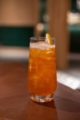 Close up view of orange cocktail on the table with bokeh background