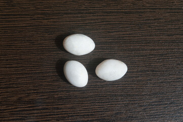 Photo of three lizard eggs on a plywood board
