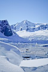antarctic panorama with icebergs and blue sky
