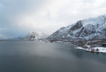 Obraz premium Snow capped mountains along a fjord near Holdoya Island, Lofoten, Norway