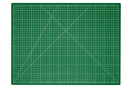 A big green cutting mat with a white grid is isolated.