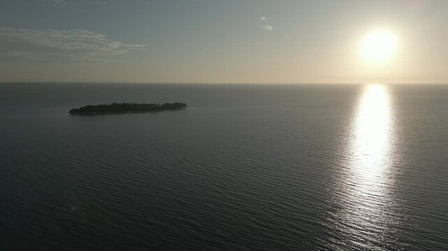 Drone pull-out shot of sunset at Potipot Island with calm sea in Zambales, Philippines
