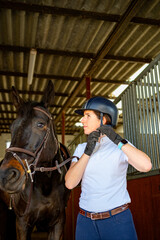 Woman rider putting her helmet before riding
