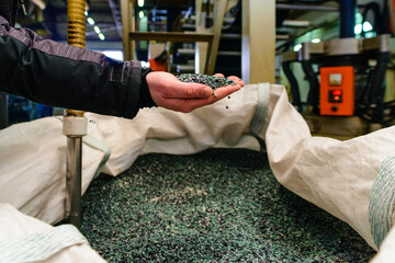 hands hold or touching biodegradable plastic pellets, plastic polymer granules