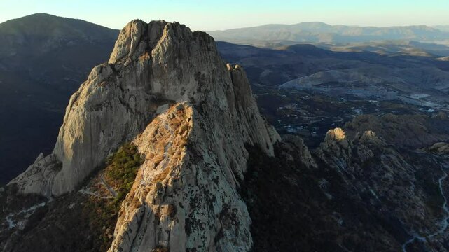 Bernal Rock Mountain in Queretaro at Sunset, famous place in Mexico for rappelling. Pena de Bernal, Aerial shot.
