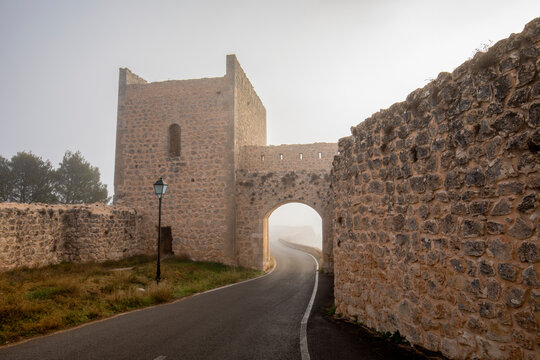 Puerta del Calabozo in the medieval wall of the town of Alarcon, Cuenca, Castilla-La Mancha, Spain, on a foggy day