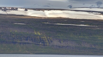 côte nord de l'Islande, falaise et plateau enneigé avec villages colorés