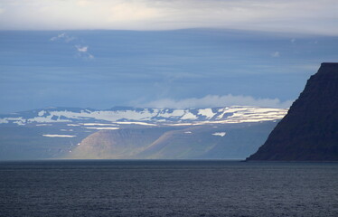 côte nord de l'Islande, falaise et plateau enneigé avec villages colorés