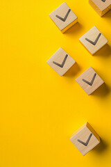 Check symbol on wooden cube on yellow background generated.AI