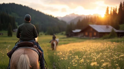 Fototapete Rund Two riders enjoy a serene horseback experience across a breathtaking mountain landscape at sunset, symbolizing tranquility and a connection to nature. © Dulemegapixel