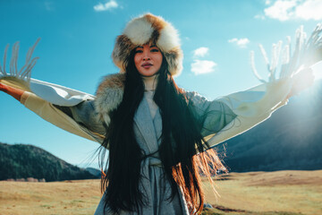 Young traditional kyrgyz woman portrait in high mountains on sunny day