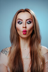 Fototapeta premium Young woman squint eyes emotional portrait, tattoo on body