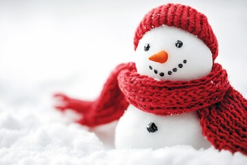 Cute snowman in a red knitted hat and scarf, sitting in snow.