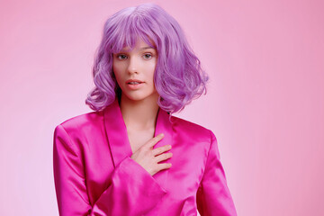 Purple wig, pink robe, woman smiling with hands on hips, posing for the camera