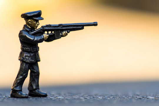Small soldier figure holding a rifle in focus - Powered by Adobe