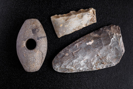 Prehistoric stone axe, isolated on black background.primitive man.Scythian period.Archaeology. Study of ancient objects