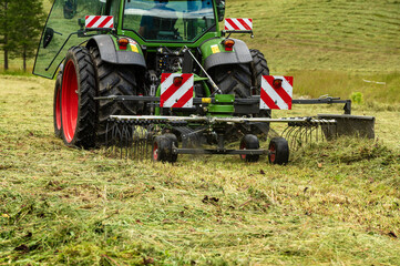  farmer who collects the hay with his tractor over  on the Swiss alps
