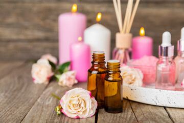 Rose essential oil on a textured background.Roses and a bottle of rose perfumed water.Aromatherapy treatment. Beauty concept. Spa procedure.Natural organic oil.Anti-stress,detox relax.Place for text