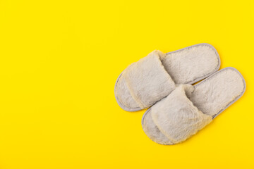 Soft slippers on a bright colored background, close-up. House slippers. Comfortable shoes for home. Foot care concept. Home comfort. Space for text. Copy space.