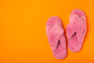 Soft slippers on a bright colored background, close-up. House slippers. Comfortable shoes for home. Foot care concept. Home comfort. Space for text. Copy space.