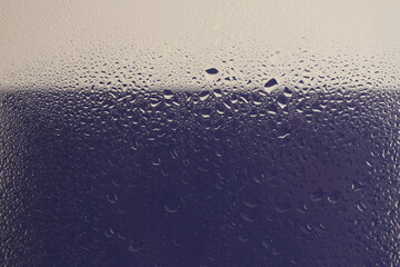 Soft focus  through aquarium glass with wet water drops. Abstract blue, beige background.