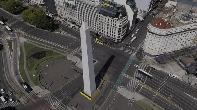 Drone orbits to the left at high angle over obelisk at Plaza de la Republica in Buenos Aires, Argentina