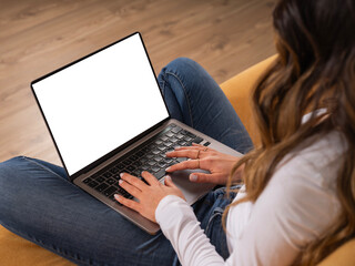 Over shoulder laptop mock up, young caucasian brunette teen girl student sitting couch at home...