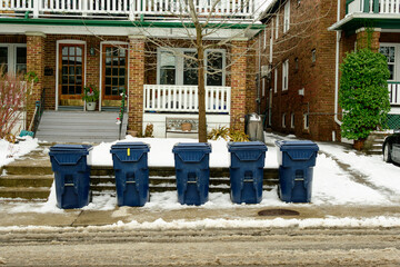 green economy: recycling bins waiting for collection on a residential street shot in winter with...