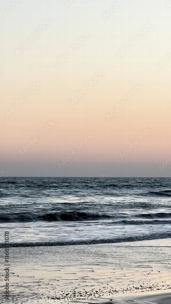 Poster calm ocean waves gently lapping on a sandy beach at sunset with a soft pastel sky creating a serene 