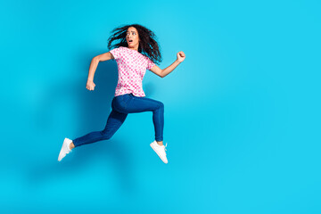 Full length photo of shiny attractive lady dressed pink t-shirt running jumping high empty space isolated blue color background