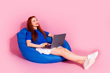 Full length photo of shiny attractive lady dressed mini skirt relaxing bean bag chatting modern gadget empty space isolated pink color background