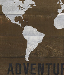Rustic world map art, white continents painted on a wood background.