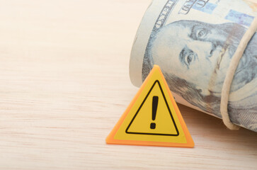 the warning sign and the money serves as a reminder of the importance of financial responsibility...