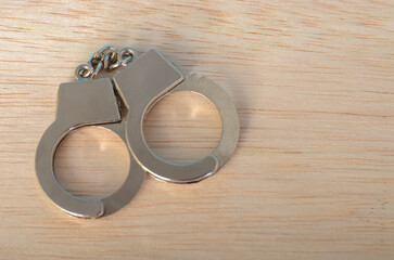 The handcuffs, typically associated with law enforcement and arrest, serve as a reminder of the...