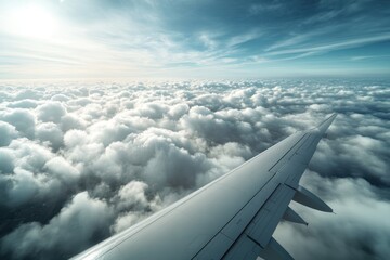 Journey above the clouds while soaring in a silver airplane under a vast blue sky as sunlight breaks through fluffy white formations